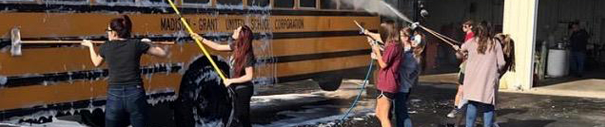 students washing a bus