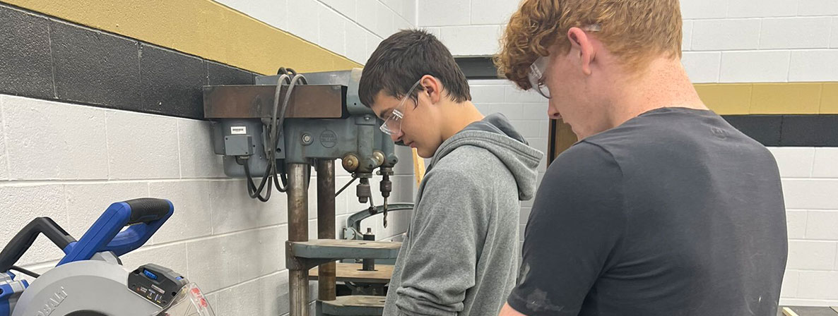 Two students in workshop with a tablesaw